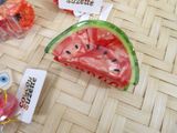 a piece of watermelon sitting on a table next to other items