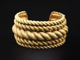 un gros plan d'un bracelet en chaîne dorée sur fond noir
