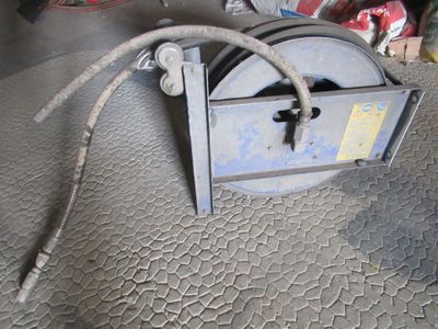 une machine posée à même le sol, à laquelle est raccordé un tuyau