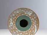 une assiette verte et blanche avec un trou noir au centre