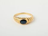 une image d'une bague en or avec une pierre bleue
