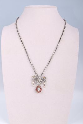 silver necklace with red and white crystals on a mannequin neck