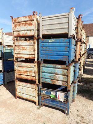 a stack of blue and white crates in the dirt