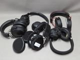 a lot of headphones that are sitting on a table