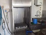 a large stainless steel oven in a kitchen with a blue bucket on the counter