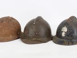 three helmets are lined up in a row on a white surface