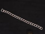 a close up of a silver chain bracelet on a black background