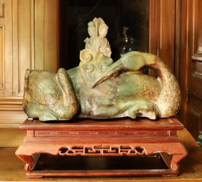 une statue représentant une femme allongée sur une table en bois