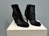 des bottines en cuir noir avec des fermetures éclair, montées sur un socle blanc