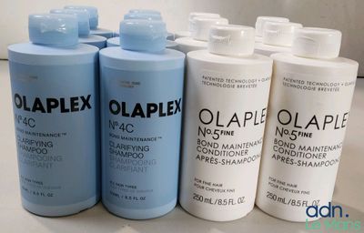 Quatre flacons d'Olaplex sont alignés sur un comptoir