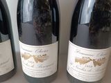 three bottles of wine are lined up on a table