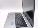 a silver laptop with a black keyboard on a white surface
