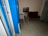 a room with a couch and a refrigerator in it