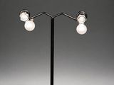 a pair of lamps on a black metal stand with white bulbs