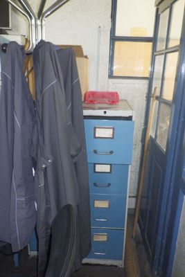 deux manteaux suspendus à un porte-manteau à côté d'un classeur