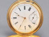 an old gold pocket watch with roman numerals on the face