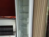 un réfrigérateur avec une porte vitrée à côté d'une cuisinière