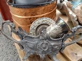 a metal object on a wooden pallet next to a vase