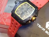 La montre est rouge et noire, avec un cadran jaune.