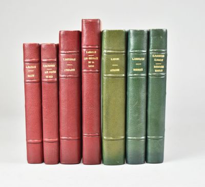 several books are lined up in a row on a white surface