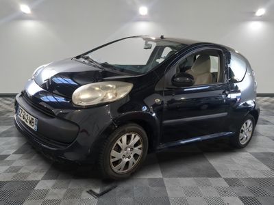 la photo d'une petite voiture noire sur un sol en damier