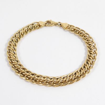 une image d'un bracelet en chaîne en or sur fond blanc