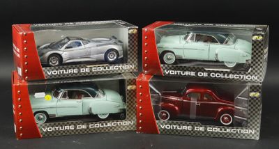 three toy cars are in a box on a black surface