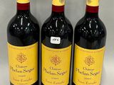 three bottles of red wine are lined up on a white surface