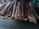 many rolls of fabric sitting on a shelf in a room