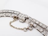 a close up of a diamond bracelet on a white surface