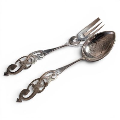 two spoons and a fork on a white surface