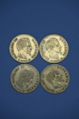 quatre types différents de pièces d'argent sur un fond bleu