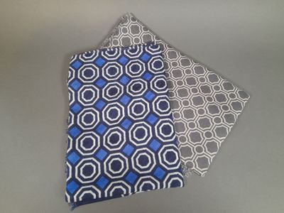 pair of blue and white patterned neck ties on a gray surface
