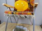 a yellow balloon sitting on top of a chair next to a box