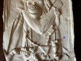 an image of a stone relief of a man with a hat and a beard