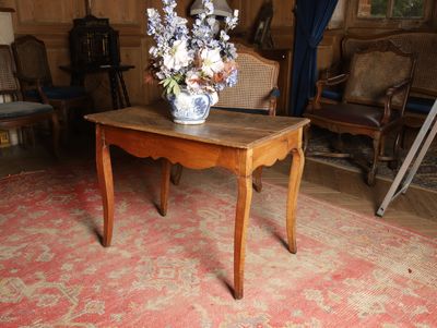 une petite table sur laquelle se trouve un vase de fleurs