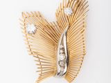 an image of a gold and diamond broochle on a white background
