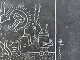 chalk drawing of a man riding a horse with a robot in the background