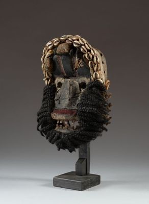 a close up of a mask on a stand on a white surface