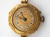une image d'un gros plan d'une montre-bracelet sur une surface blanche