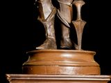bronze statue of a man with a sword and shield on a pedestal