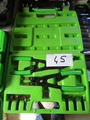 de nombreux outils rangés dans une mallette verte posée sur une table