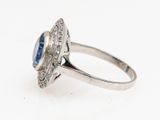 a close up of a ring with a blue stone surrounded by diamonds