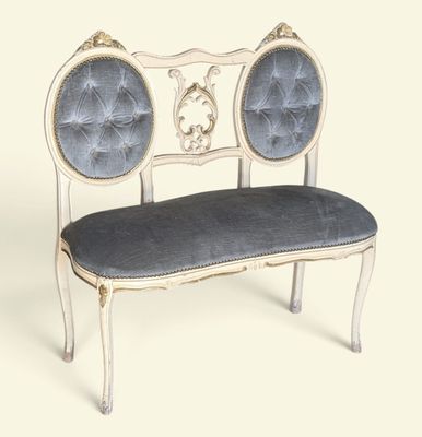 a white bench with a blue cushion on it