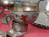 de nombreux objets en argent posés sur une table rouge recouverte d'une nappe rouge
