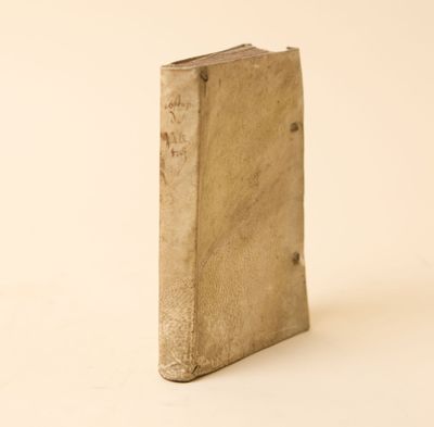 un vieux livre est posé sur une surface blanche avec un fond blanc