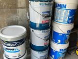 several buckets of paint sitting on the floor next to each other