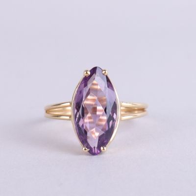 gros plan d'une bague en or avec une pierre en améthorate