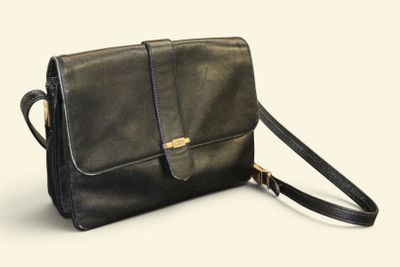 black leather cross body bag with shoulder strap on a white background