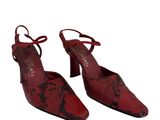 une paire de chaussures en peau de serpent rouge sur fond blanc